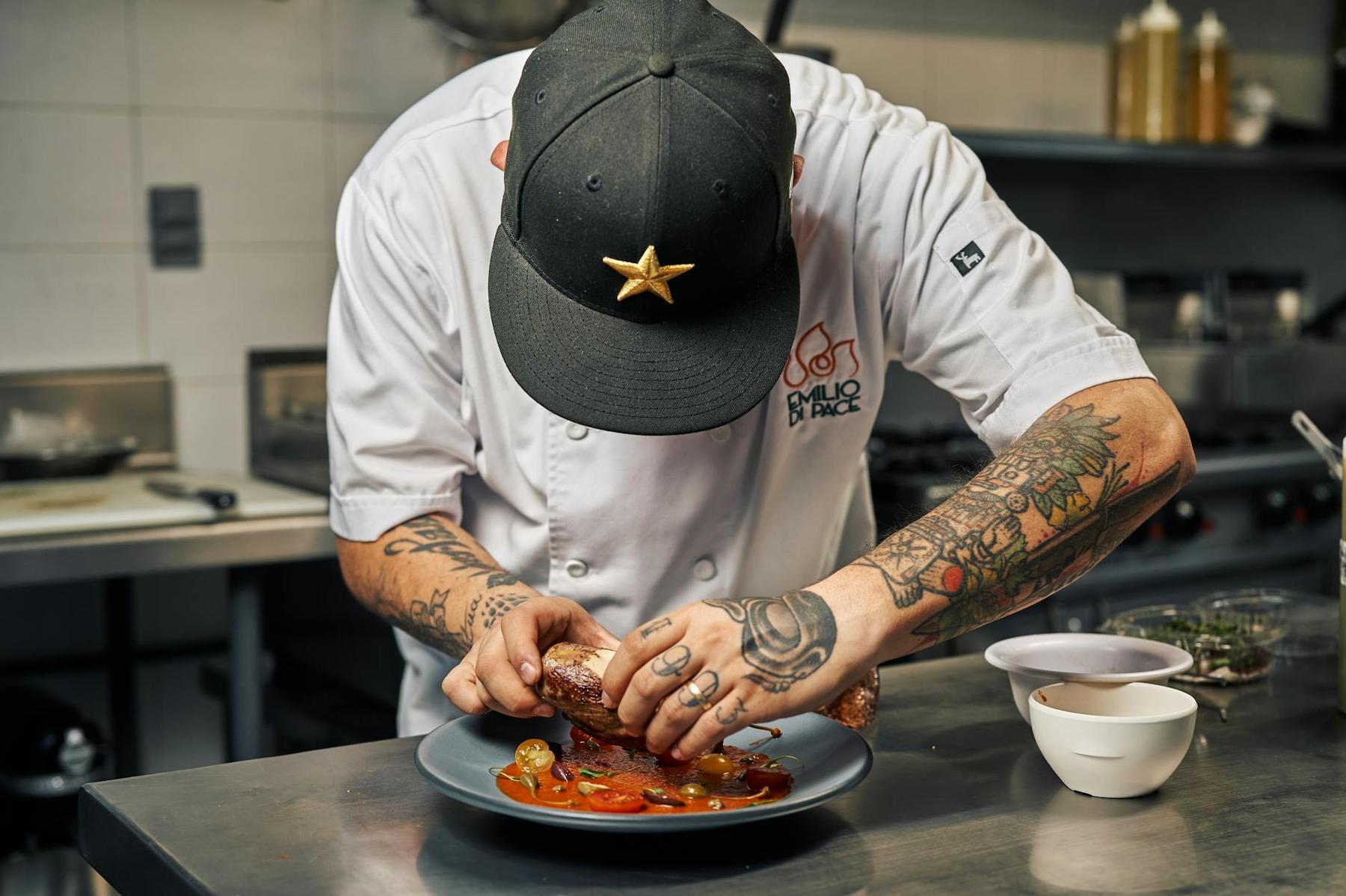 Chef carefully plating a modern dish at an Auckland fine dining restaurant