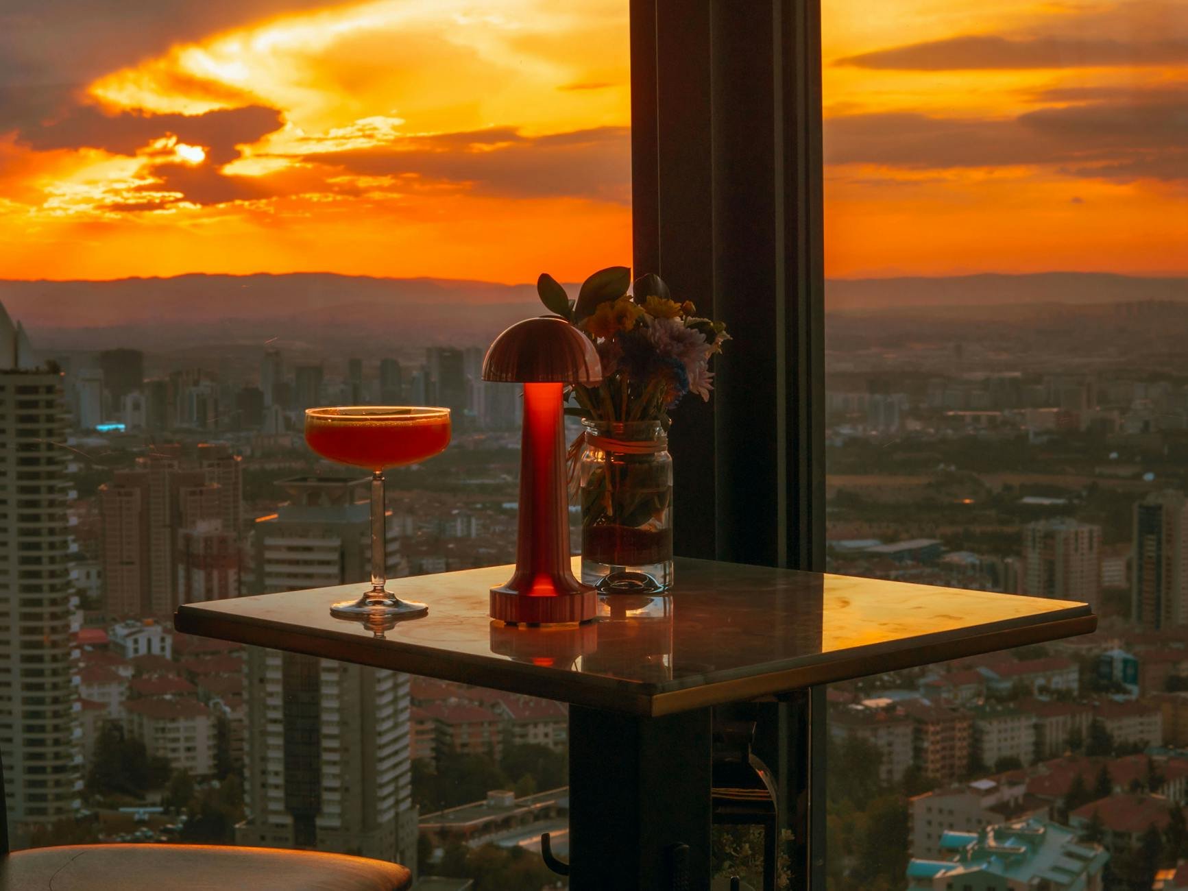 Evening cocktails at a rooftop bar with city skyline like Auckland rooftop bars